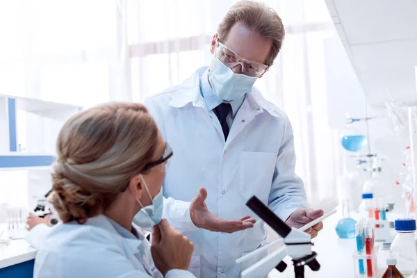 Médicos conversando enquanto trabalham em laboratório — Fotografia de Stock