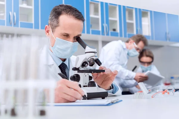 Scientist working with microscope — Stock Photo