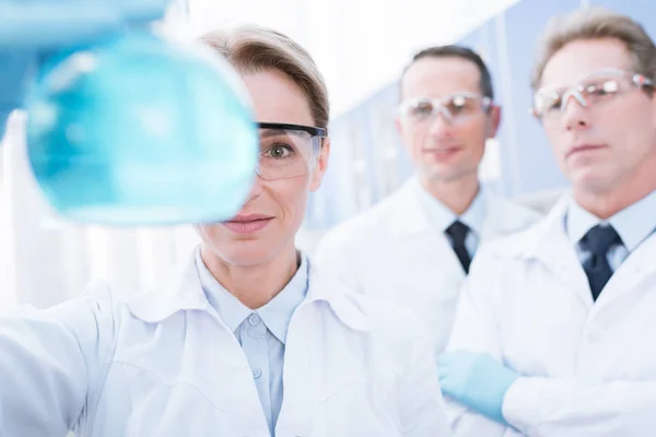 Doctor showing flask with reagent — Stock Photo