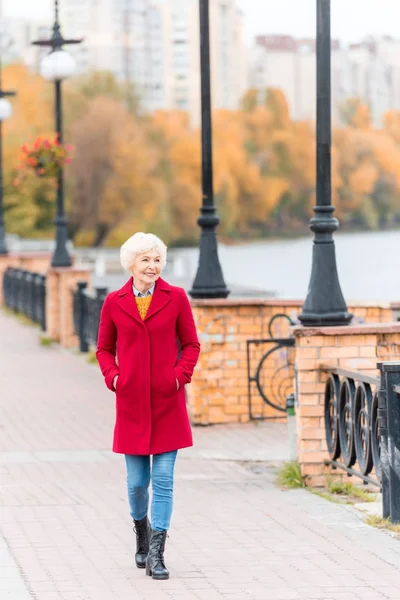 Mujer mayor con abrigo rojo - foto de stock