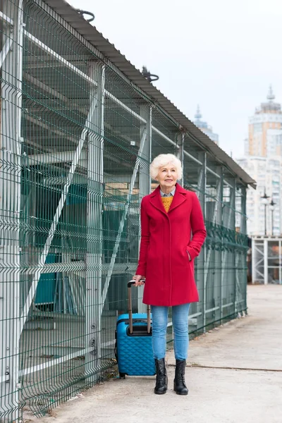 Пожилая женщина с чемоданом — стоковое фото