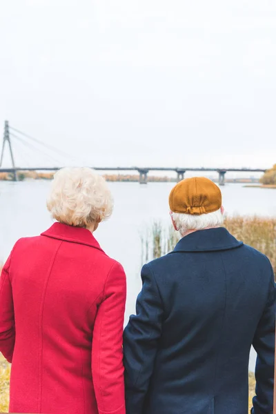 Старша пара дивиться на осіннє озеро — стокове фото