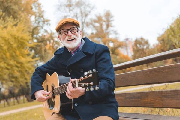 Senior man playing on guitar — Stock Photo