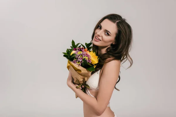 Chica en lencería sosteniendo flores - foto de stock