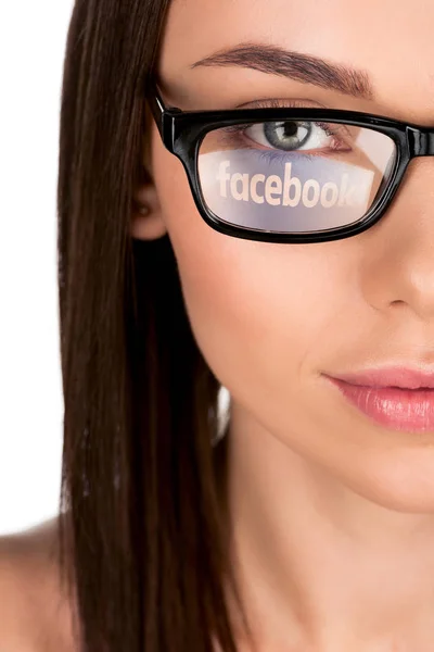 Woman with facebook logo reflection in eyeglasses — Stock Photo