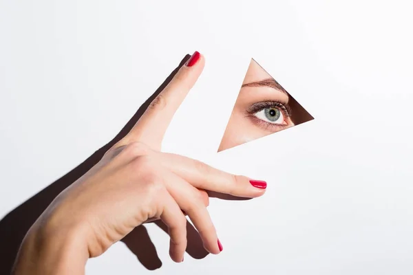 Mujer mirando por el agujero en el papel - foto de stock