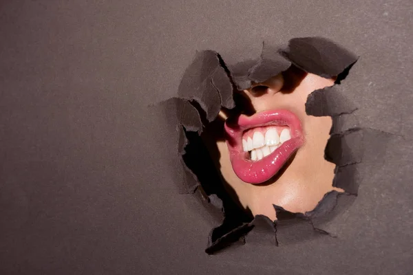 Rosa Lippen einer Frau im Papierloch — Stockfoto
