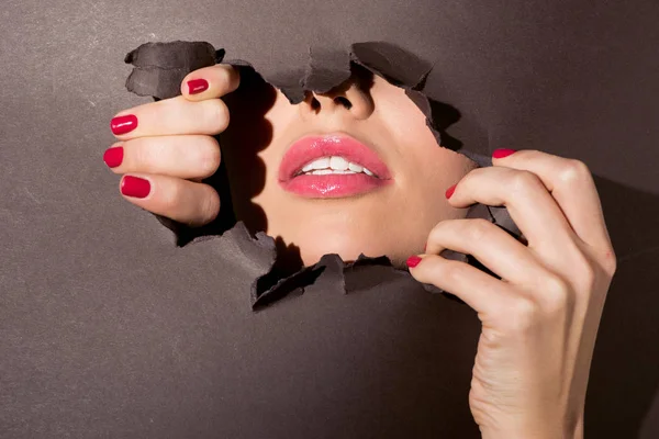 Woman peeking out of hole in paper — Stock Photo