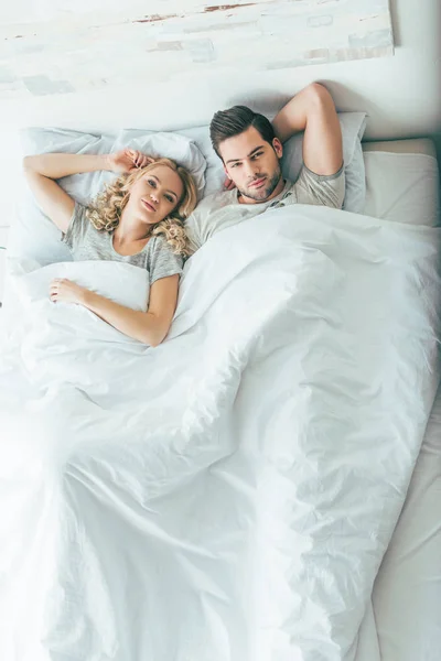 Jeune couple au lit — Photo de stock
