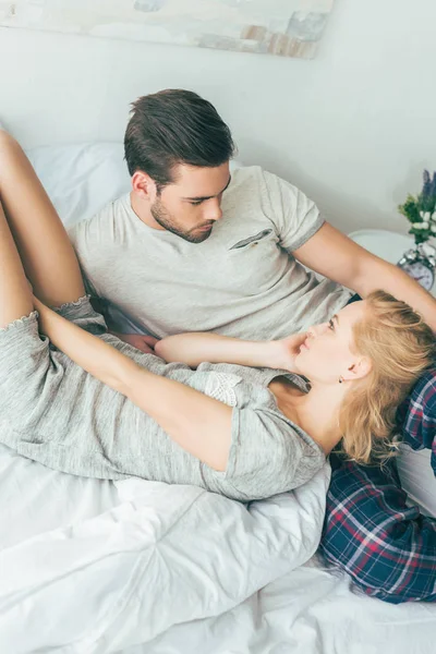 Feliz joven pareja en la cama - foto de stock