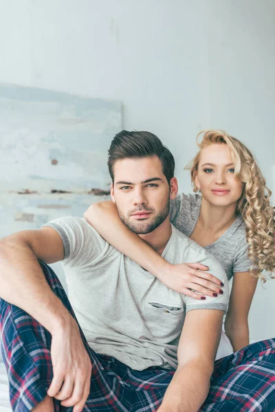 Heureux jeune couple sur lit — Photo de stock