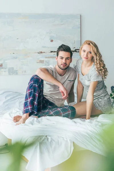 Feliz joven pareja en la cama - foto de stock