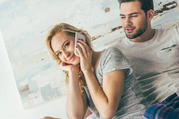 Couple utilisant un smartphone au lit — Photo de stock