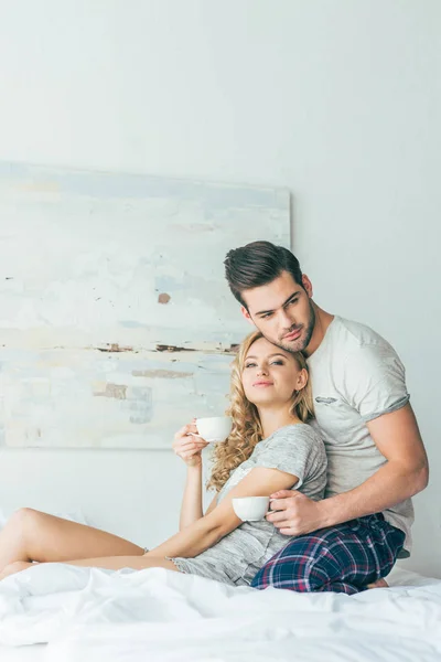 Couple drinking coffee in bed — Stock Photo