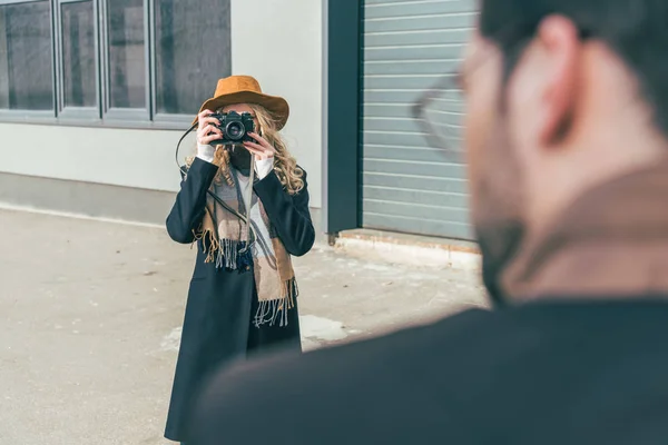 Женщина с фотоаппаратом, фотографирующая парня — стоковое фото