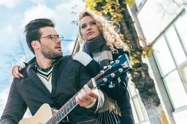 Пара в осінньому вбранні з гітарою — стокове фото
