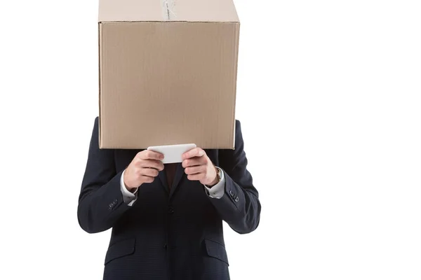 Бизнесмен с коробкой на голове с помощью смартфона — стоковое фото