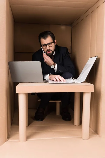 Hombre de negocios con documentos y portátil - foto de stock