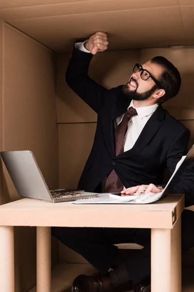 Hombre de negocios que trabaja con el ordenador portátil de cartón - foto de stock