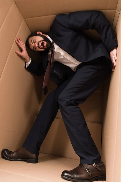 Stressed businessman in cardboard box — Stock Photo