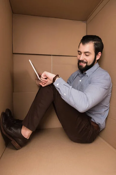 Man with tablet looking at watch — Stock Photo