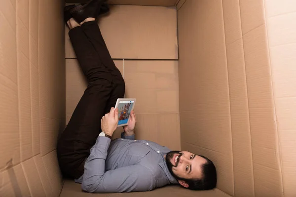 Hombre usando tableta con couchsurfing — Stock Photo