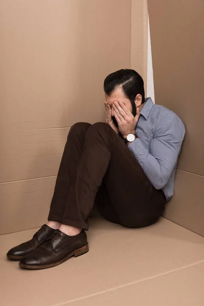 Deprimido hombre llorando en caja - foto de stock