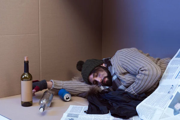 Hombre sin hogar durmiendo en caja - foto de stock