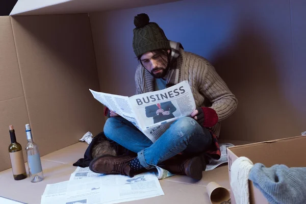 Homeless with business newspaper — Stock Photo