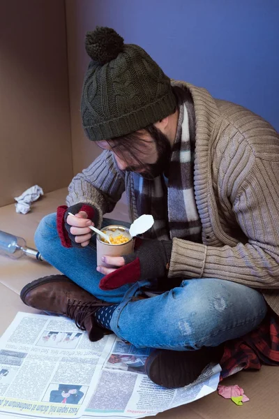 Homeless man eating canned food — Stock Photo