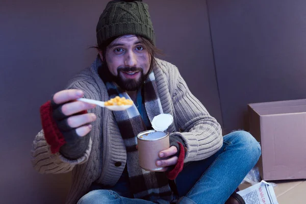 Hombre sin hogar comiendo comida enlatada - foto de stock