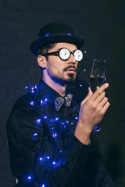 Man with champagne and christmas lights — Stock Photo