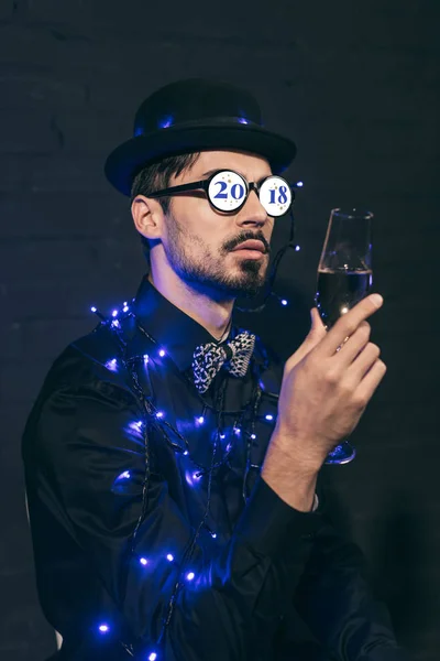Hombre con champagne y luces de Navidad - foto de stock