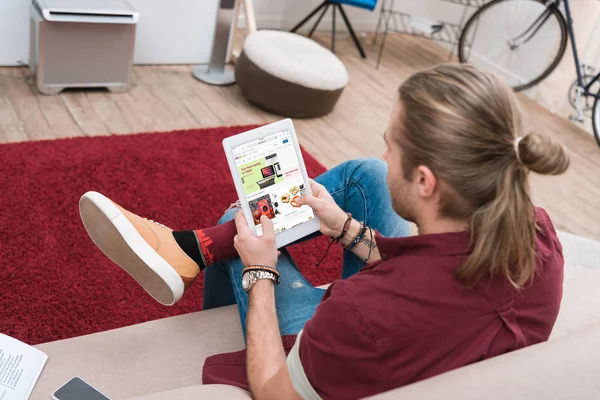 Mann sitzt auf Sofa beim Online-Einkauf auf digitalem Tablet mit ebay-Gerät — Stockfoto