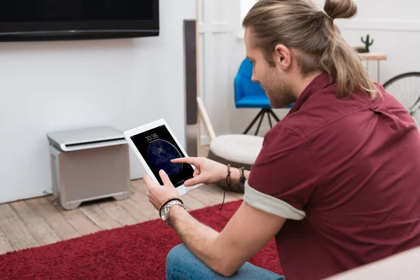 Mann sitzt auf Sofa, während er ipad Tablet benutzt — Stockfoto