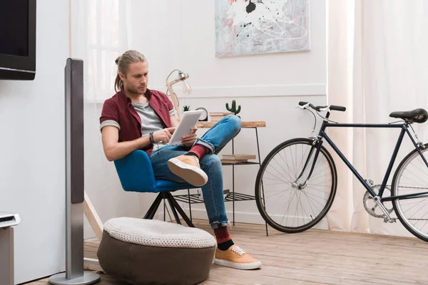 Bell'uomo che usa tablet a casa con la bicicletta — Foto stock