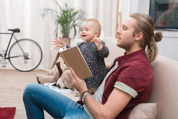 Parent reading book to happy daughter at home — Stock Photo
