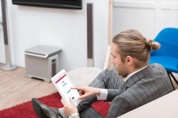 Businessman using digital tablet with instagram website at home — Stock Photo