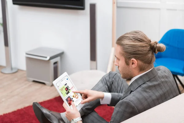 Businessman using digital tablet with ebay website at home — Stock Photo