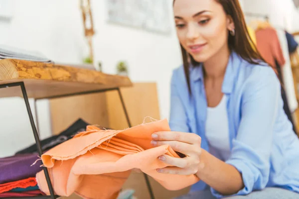 Smiling designer holding yellow fabric — Stock Photo