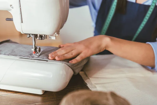 Обрезанный образ шитья швеей с швейной машинкой — стоковое фото
