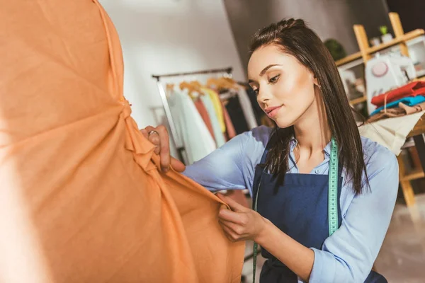 Atraente alfaiate fazendo vestido no manequim — Fotografia de Stock