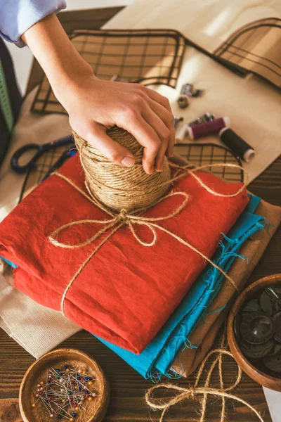 Abgeschnittenes Bild der Näherin, die Hand auf Garnspule legt — Stockfoto