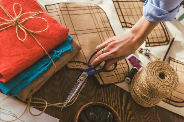 Cropped image of seamstress taking scissors — Stock Photo