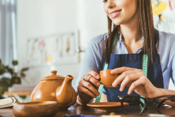 Image recadrée de couturière buvant du thé pendant le déjeuner — Photo de stock