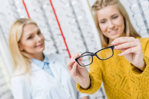 Augenarzt hilft Klient, Brille in Optik zu wählen — Stockfoto