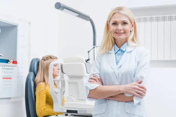 Жінка-окулістка вивчає пацієнта через лампу в клініці — стокове фото