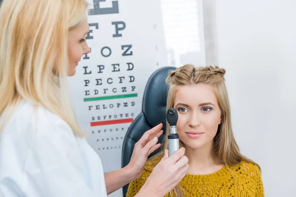 Augenarzt untersucht schöne Patientin in Klinik — Stockfoto