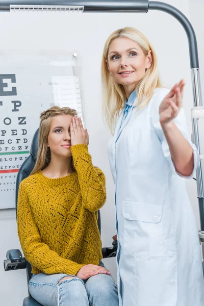 Gestualità oculista durante l'esame paziente attraente in clinica — Foto stock