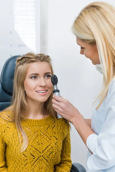 Atractivo oculista examinar hermoso paciente en clínica - foto de stock